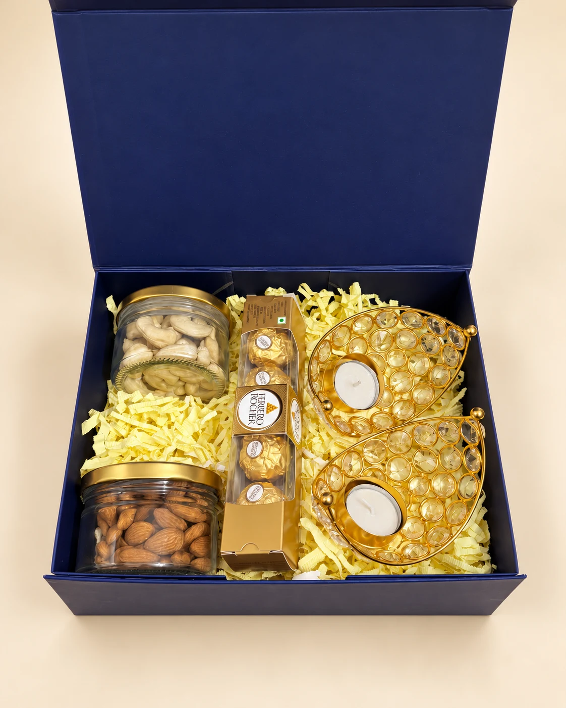 Navy gift box with jars of cashews and almonds, chocolates and gold candle holders