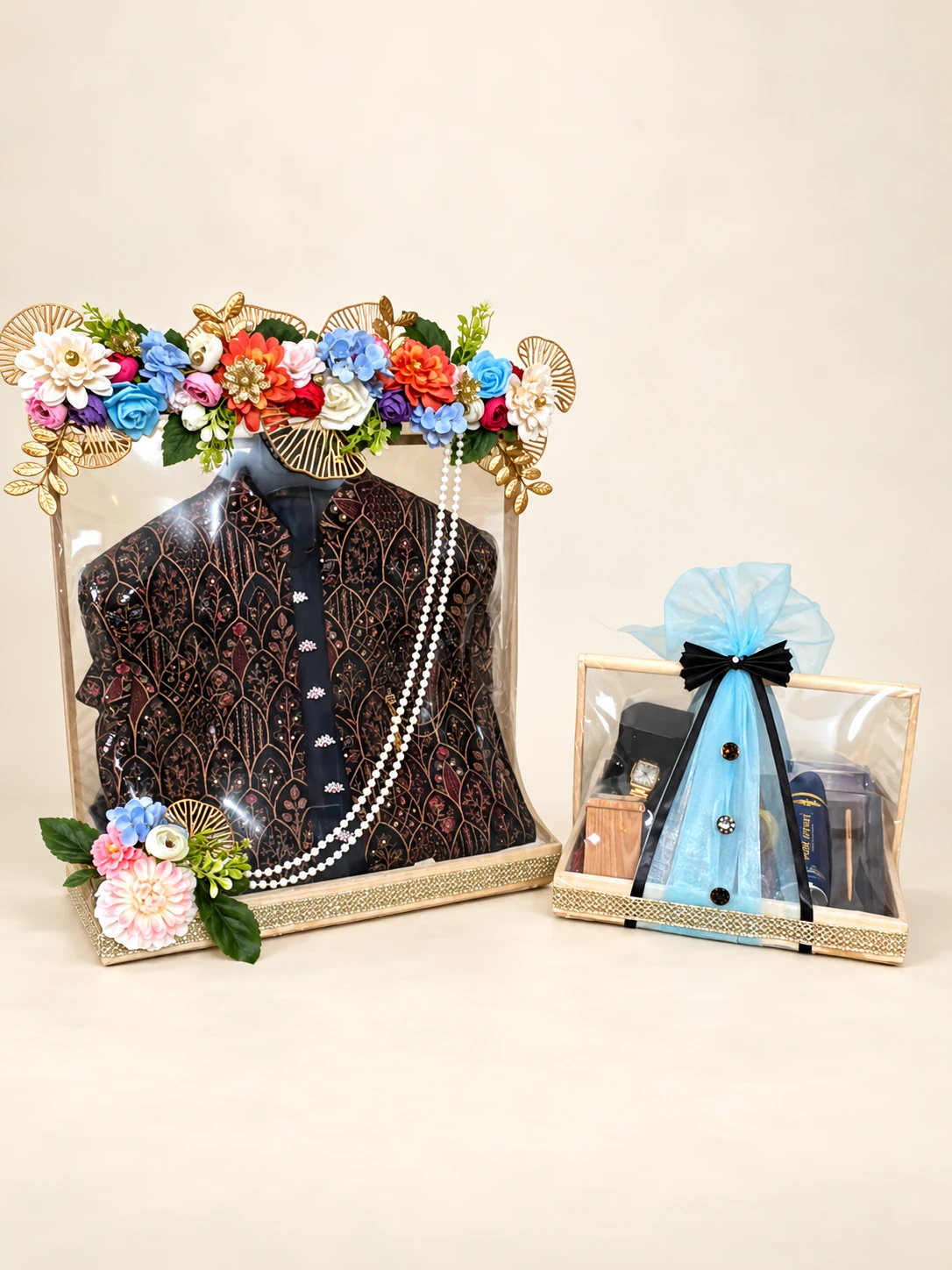 Framed groom's jacket display with flowers and pearls, beside a matching accessories tray