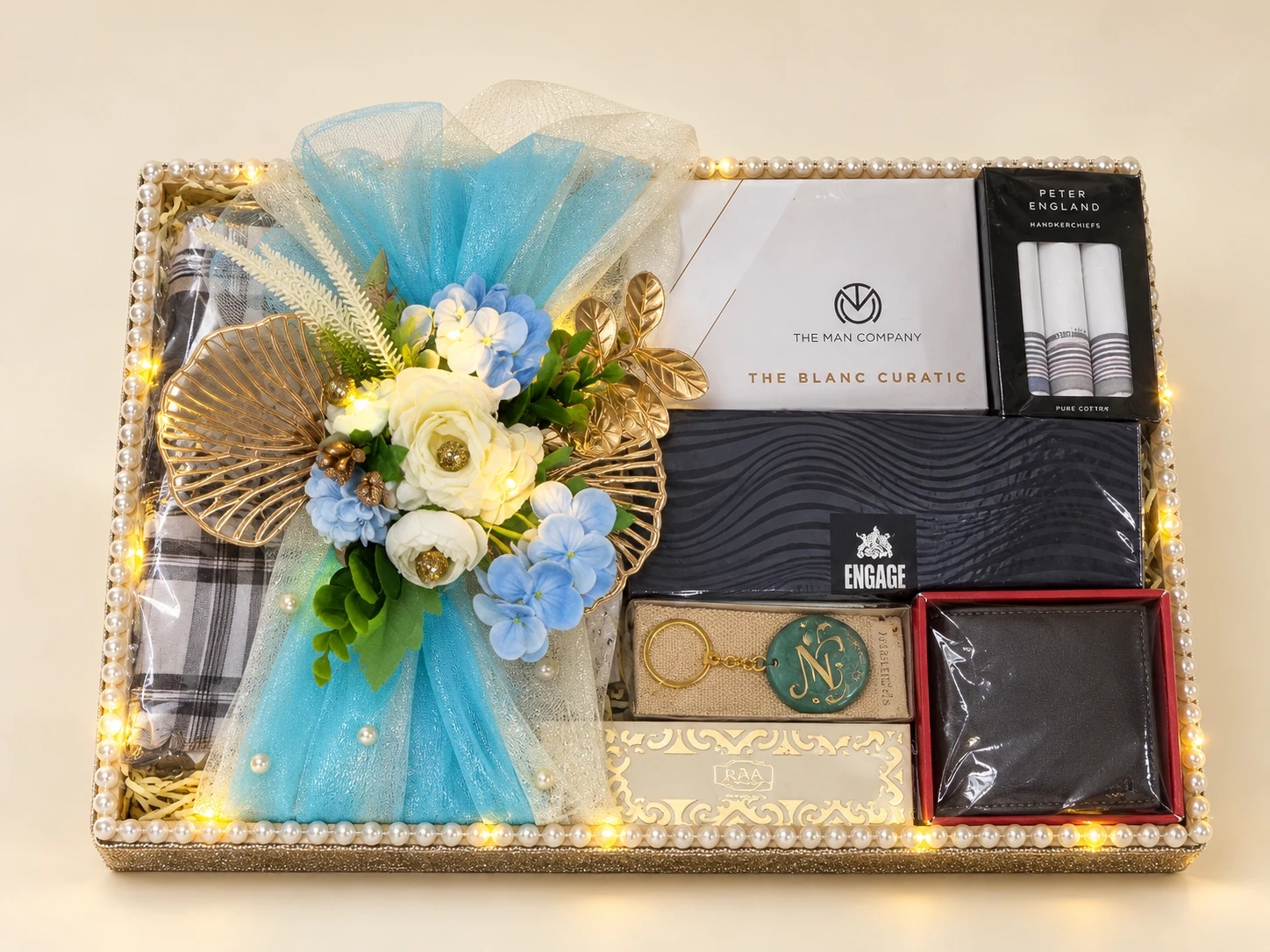 Gift tray with a wallet, perfume, handkerchiefs and a blue net bow with flowers