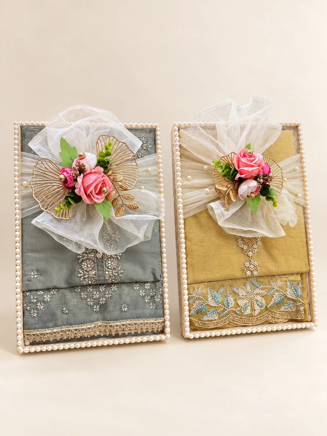 Two clothing trays in grey and gold, each with a net bow and roses